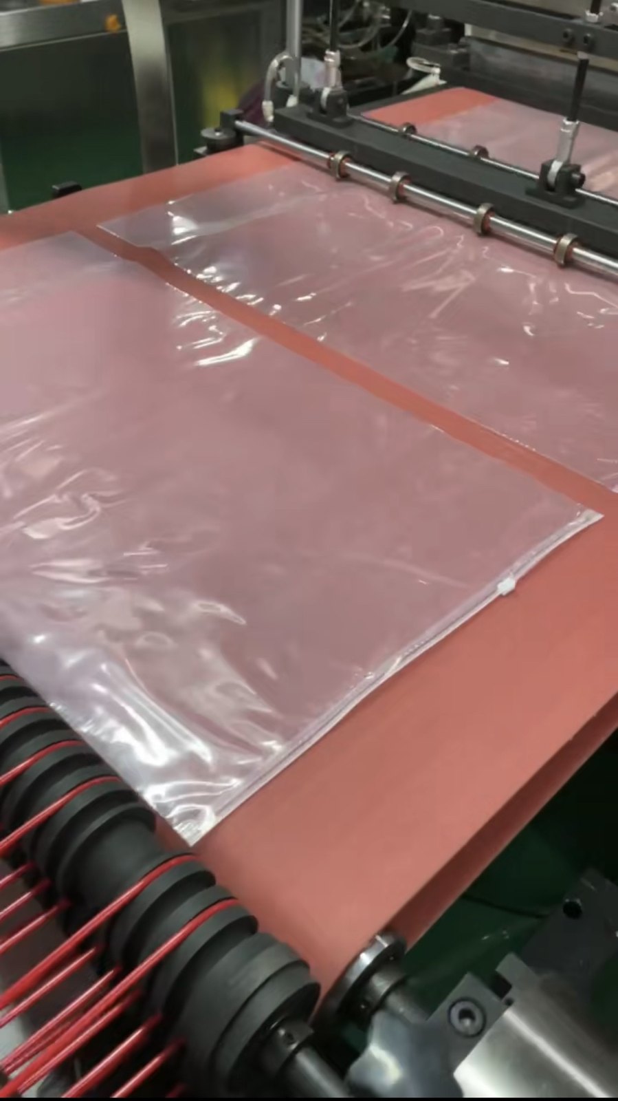 red silicone conveyor belt operating on a zipper bag-making machine