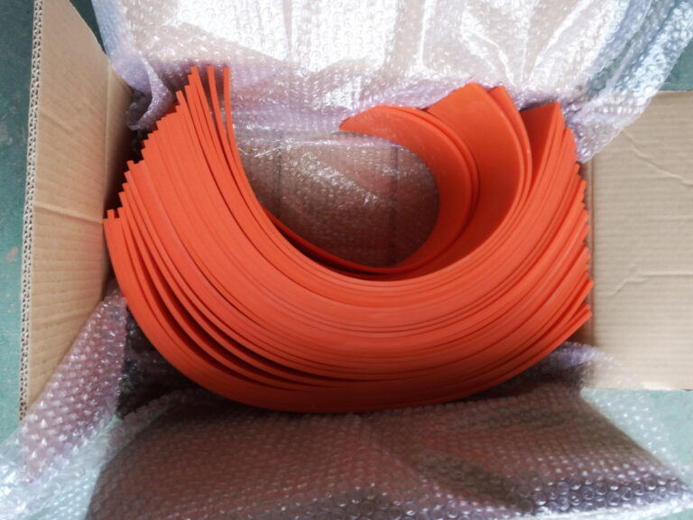 Red compression-resistant silicone sheet for a plastic bag making machine packed for shipment